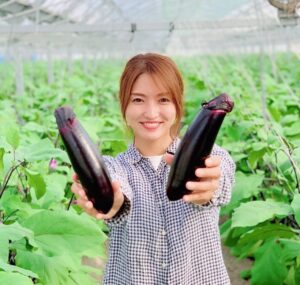 なすを掲げる美人農業女子